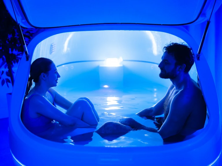 Пара в открытой флоат-капсуле с синей подсветкой в FLOTARIUM
